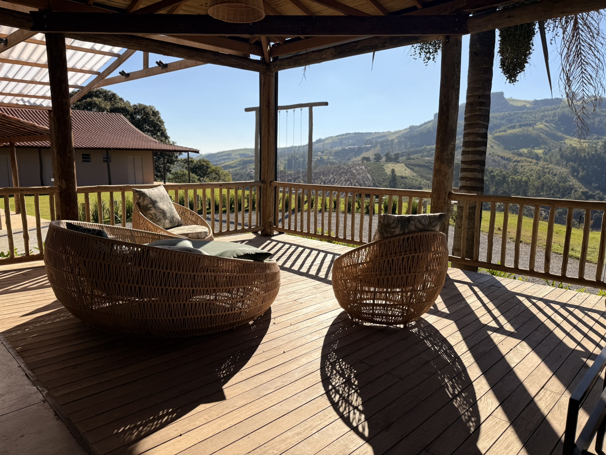 Deck com poltronas de vime e vista para o vale