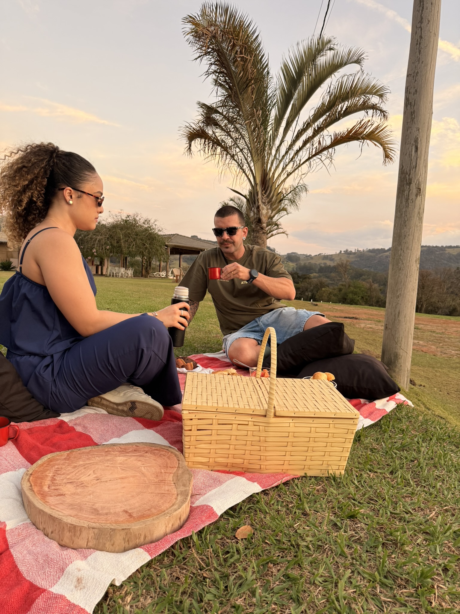 Casal ao fim da tarde, com vinho e a montanha à frente