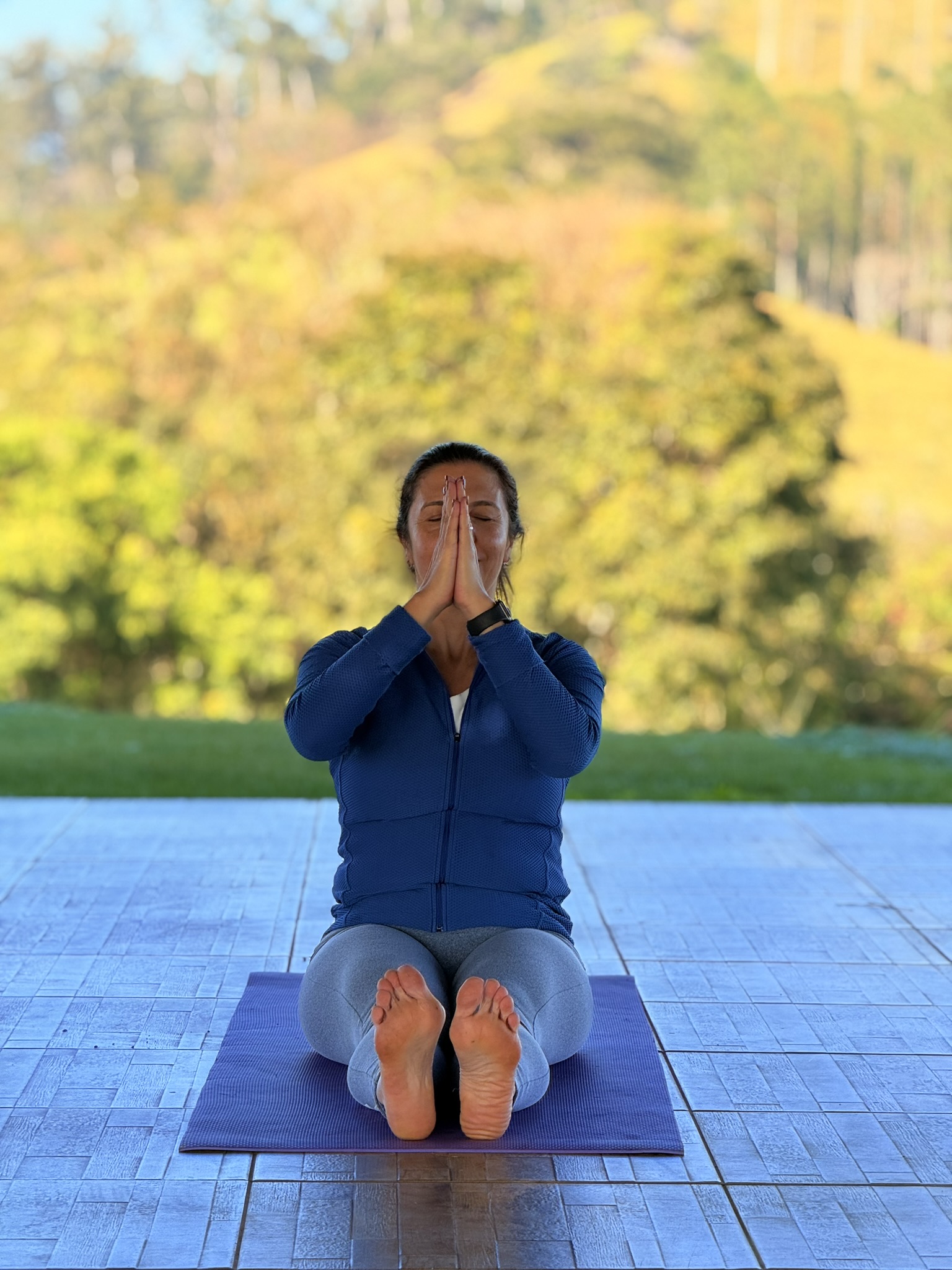 Prática de yoga ao ar livre, de frente para o vale