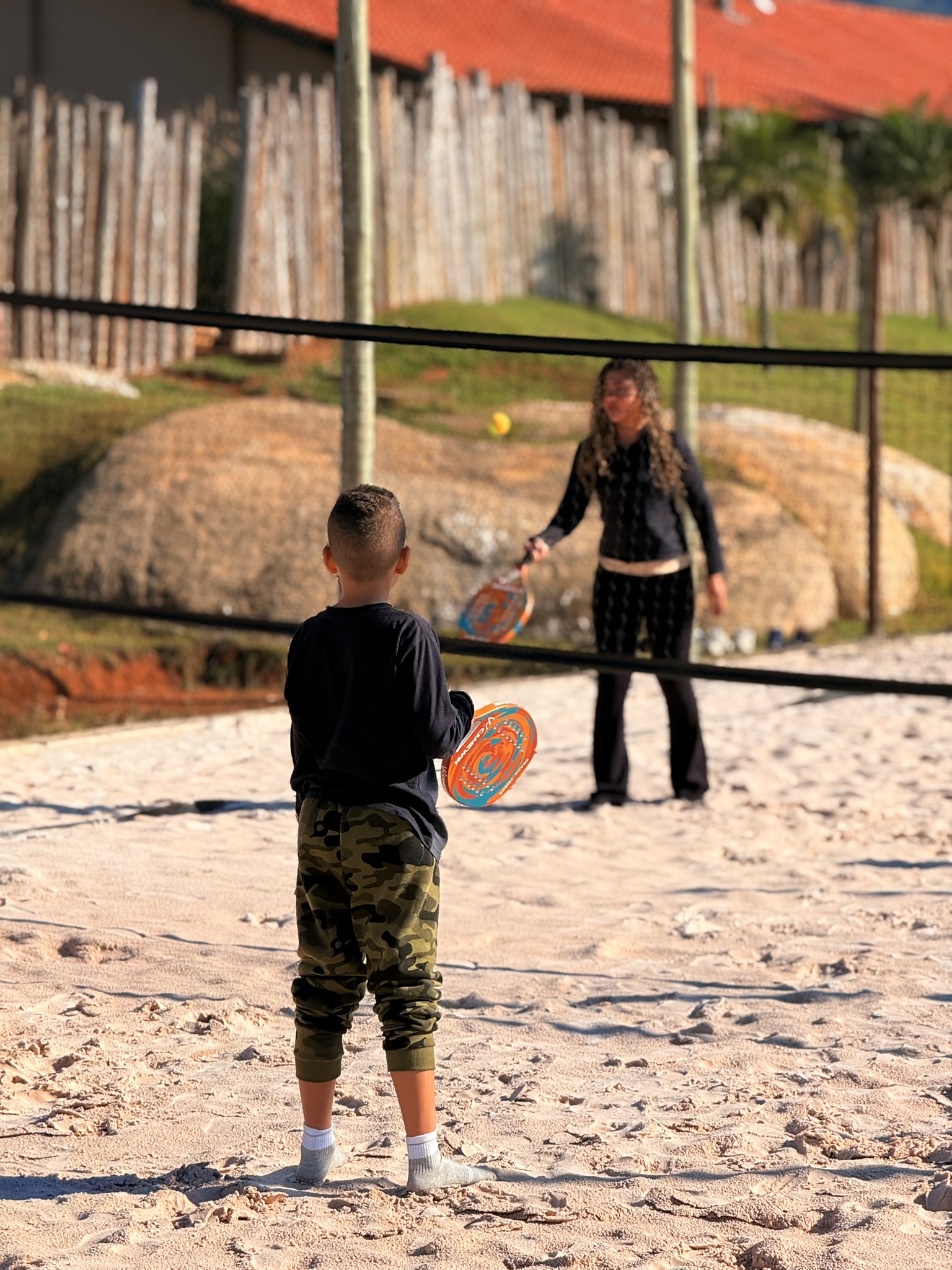 Beach tennis na quadra de areia, no fim da tarde